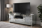Silver mirrored TV stand with a television mounted on a gray wall. The Roma TV Unit is designed to complement contemporary, glam, and luxury interiors. Its mirrored surfaces and crystal-style accents add brightness and depth to your room, making it an eye-catching centrepiece whether styled alone or paired with matching Roma furniture.
Sizes Available in two sizes to suit your space and TV setup of your
120 cm (W) x 45 cm (D) x 55 cm (H)
150 cm (W) x 45 cm (D) x 55 cm (H)