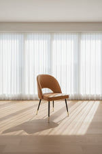 Tan chair with black legs on a white background