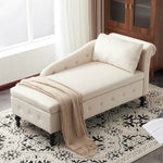 An off-white upholstered chaise lounge with a matching pillow and a beige knit throw blanket, styled on a patterned rug in a bright room.