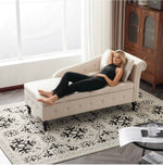 Woman lying on a beige chaise lounge in a living room with a wooden cabinet and rug.