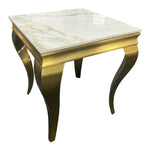 A rectangular gold-colored lamp/side table with a marble effect surface and decorative, curved legs.
