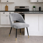 Gray velvet chair with gold feet in a kitchen setting