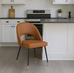 Elevate your seating with this sophisticated Venice chair, crafted from durable polyurethane upholstery in a warm tan finish. The sleek black legs are accented with refined gold feet, creating a striking contrast that complements contemporary and transitional interiors alike. Designed for both aesthetic appeal and everyday comfort, this chair delivers the perfect balance of style and functionality. Its streamlined silhouette makes it an ideal addition to living rooms, bedrooms, or home offices where underst