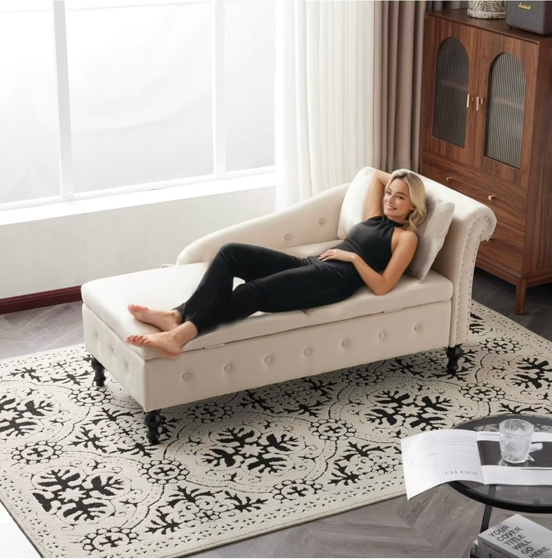 Woman lying on a beige chaise lounge in a living room with a wooden cabinet and rug.