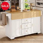 A white kitchen island cart with a light wood countertop, shown in a bright kitchen setting. The cart features three drawers on the right with gold knobs, a cabinet door on the left, and a fold-down side arm holding a beige towel.